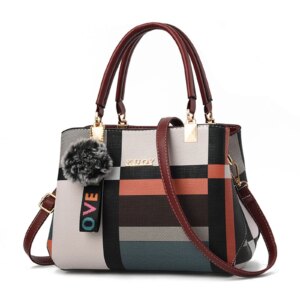 A stylish luxury shoulder tote bag displayed against a neutral background, showcasing its chic design and spacious interior